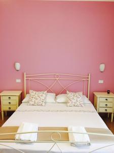 莱切省卡斯特罗查希尔住宿加早餐旅馆的一间卧室配有一张粉红色墙壁的床