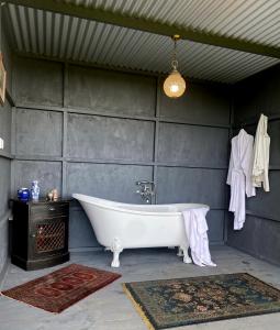 陶朗加Thistle and Pine Cottage Farmstay的带浴缸的浴室和灰色的墙壁