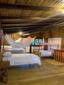 莫姆皮切Mompiche Island Hostel的一间设有四张床的客房,其中配有吊床