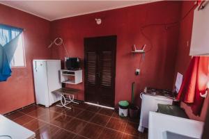 巴拉格兰德Sobrado do Eduardo的一间厨房,设有红色的墙壁和黑色的门