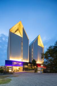 Ban Khlong SamrongBlue Hippo Hotel的一座在晚上有两座高塔的大建筑