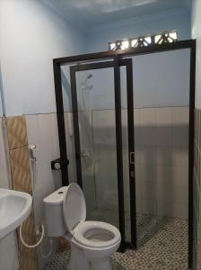 龙目岛库塔Merendeng Hostel Kuta的带淋浴、卫生间和盥洗盆的浴室