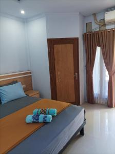 龙目岛库塔Merendeng Hostel Kuta的一间卧室配有一张带两个枕头的床