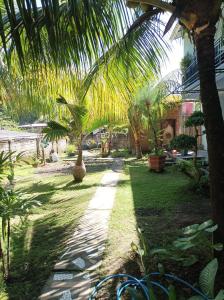 龙目岛库塔Merendeng Hostel Kuta的种有棕榈树和步道的花园