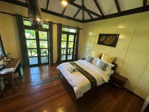 西必洛西必洛森林边缘度假村的卧室配有一张床、一张书桌和窗户。
