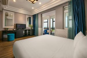 河内Ja Cosmo Hotel and Spa的卧室配有一张白色大床和电视。