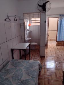 隆德里纳Hospedagem A Vale Verde的一间带床和桌子的浴室以及一间卫生间