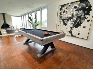 洛杉矶Urban Oasis: Stylish Mid-Century Home in Weho的客厅配有一张台球桌和绘画作品