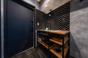 东京Inn The Omotesando的一间带水槽和黑色墙壁的浴室