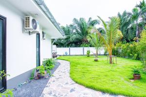 奥南海滩RUSARDI Poolvilla Ao Nang - new Villa 4 Bedrooms 4 Bathrooms, 10m Pool的一个带棕榈树的草地庭院