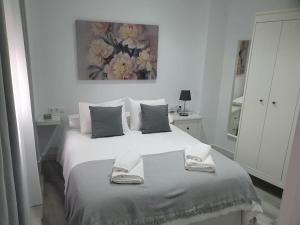 麦地那西多尼亚Precioso apartamento con patio interior.的白色卧室配有带2条毛巾的床