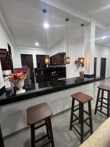 卡卢特勒DreamScape Holiday Apartment Kalutara的厨房配有黑色柜台和一些凳子
