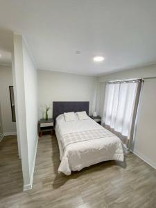 利马Miraflores House C&F的一间白色客房内配有一张大床的卧室