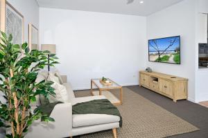 穆卢拉巴Stunning Mooloolaba Waterfront Home -10 guests ZB1的客厅配有沙发和墙上的电视