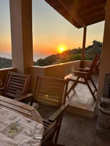 NénitaGavrilis Apartments的一个带桌椅的阳台,享有日落美景