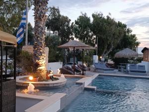纳克索斯岛卡斯特拉基Naxos Summerland resort的一个带火坑的游泳池和一个度假村