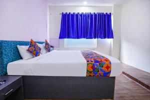 钦奈FabExpress Sanva, Pallikaranai的一间卧室配有一张大床和紫色窗帘