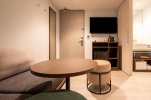 东京karaksa hotel colors Tokyo Yaesu的客厅配有桌子和沙发