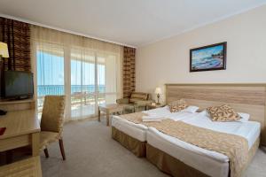 阳光海滩DIT Majestic Beach Resort - Ultra All Inclusive的酒店客房配有一张床、一张书桌和一台电视。