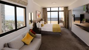 贝鲁特维达套房度假屋的一间卧室配有一张床、一张沙发和一个大窗户