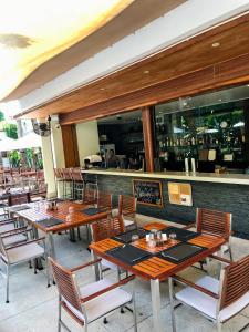 苏林海滩Beachfront 2 BR Luxury Condo Chava Surin的一间带木桌椅的餐厅和一间酒吧