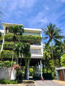 苏林海滩Beachfront 2 BR Luxury Condo Chava Surin的一座棕榈树建筑