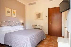 努马纳Hotel Giardino Suites&Spa的一间卧室配有一张床和一台平面电视