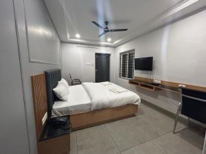 卡努尔KKM Highlands的一间卧室配有一张床和一台平面电视
