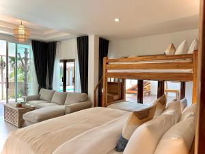 奥南海滩Villa Vara - Tropical Pool Villa的一间卧室配有一张大床和一张沙发