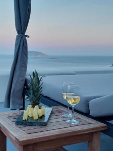 阿纳菲Apollon Village Hotel的一张桌子,上面放着一杯白葡萄酒和奶酪
