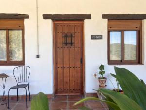 卡萨雷斯The Wild Olive Andalucía Citrus Suite的一个带椅子和桌子的房子的门