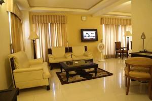 拉希迈尔汗Royal Desert Palm Hotel的客厅配有沙发、椅子和桌子