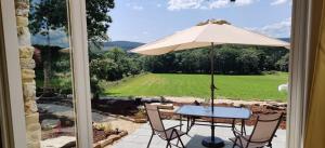 卢戈Galician Rural Accommodation - La Casita的庭院内桌椅和遮阳伞