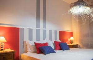 圣地亚哥－德孔波斯特拉Luxury Singular Apartments的一间卧室配有一张带红色和蓝色枕头的床