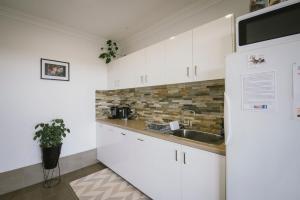 CorriginThe Mains Guest House 2 Bedroom Farm Stay的厨房配有白色橱柜和水槽