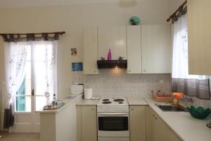 安德罗斯SummerAndros Meliti的厨房配有白色橱柜和炉灶烤箱。