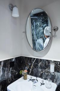 枫丹白露Hôtel & SPA Napoléon的一间带镜子和水槽的浴室