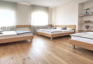 弗尔赫尼卡Guesthouse Turšič的客房内设有两张床,铺有木地板,设有窗户。