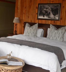 阿多Barefoot Addo Elephant Lodge的卧室配有一张带白色床单和枕头的大床。
