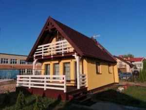 亚斯塔尔尼亚Domki Grażyna的棕色屋顶的黄色小房子