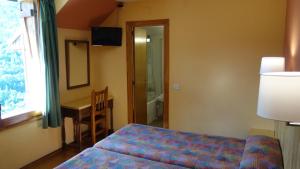 潘蒂科萨文森特酒店的一间卧室配有一张床、一张书桌和一个窗户。