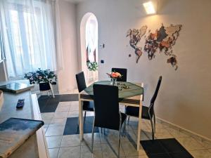普拉托Dimora del Viaggiatore的一间用餐室,配有一张桌子和椅子,墙上挂有地图