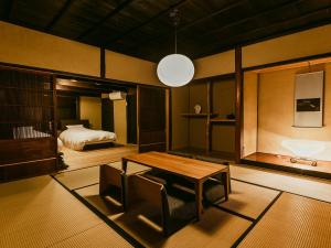 Tatsuno龍野城下町古民家ホテル kurasu的客厅配有桌子和床。