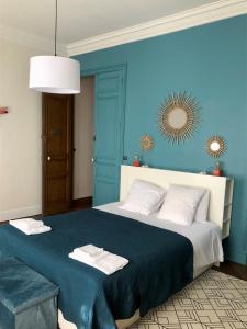 马扎梅La Grande Maison Mazamet的蓝色卧室配有一张大床和毛巾