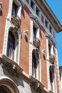 威尼斯Nolinski Venezia - Evok Collection的一座砖砌建筑,设有窗户和阳台