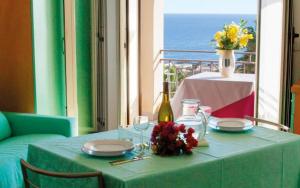 圣凯撒利亚温泉东方绿洲公寓式酒店的一张桌子,上面有绿桌布和一瓶葡萄酒