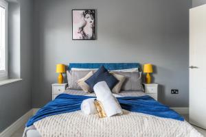 斯劳Livestay-One Bed Apt in Slough with FREE Parking的一间卧室配有一张大床,提供蓝色的床单和枕头