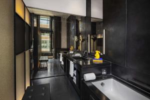 阿姆斯特丹阿姆斯特丹W酒店的黑色浴室设有浴缸和水槽
