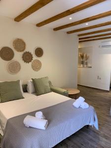 梅加尼西岛Mangata suites homes with private pools的一间卧室配有一张大床和毛巾