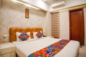 博帕尔FabHotel Divine Casa的一间卧室配有一张带彩色毯子的床